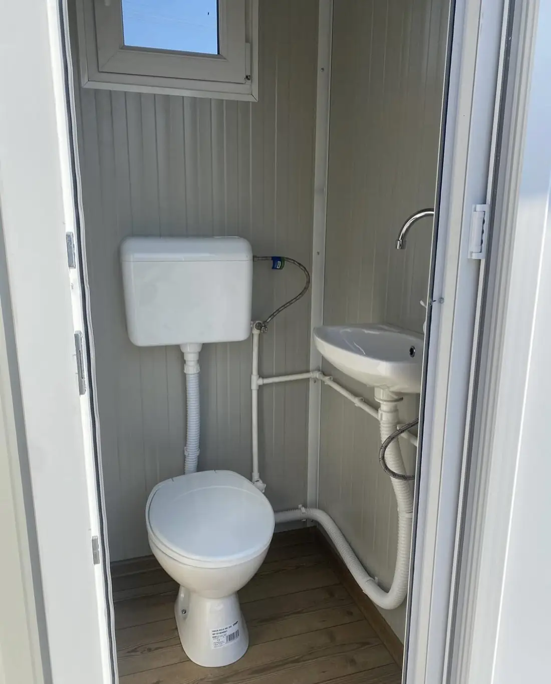 Flushing portable toilet interior with a sink